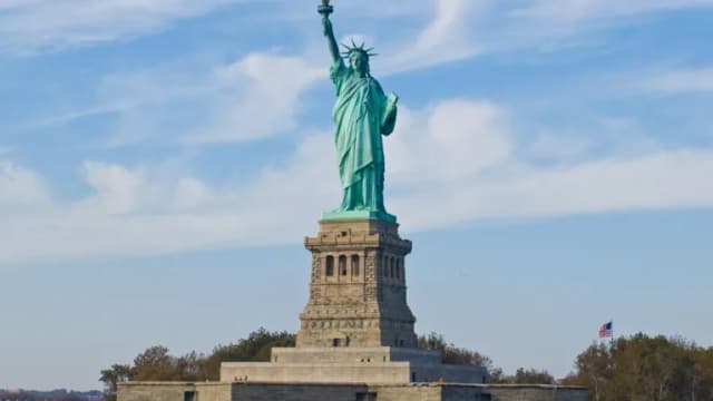The Statue of Liberty on Liberty Island under a blue sky