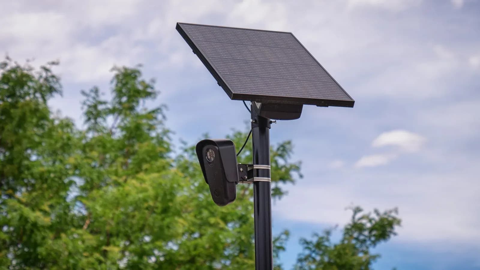 A Flock Safety license plate reader camera mounted on a pole with a solar panel