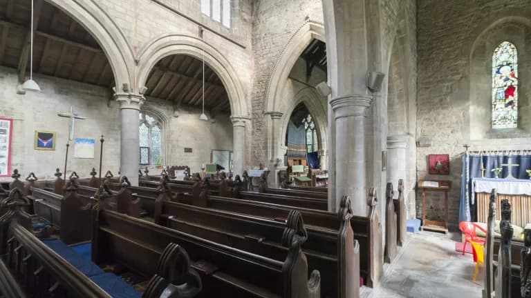 Empty wooden pews inside an old stone church