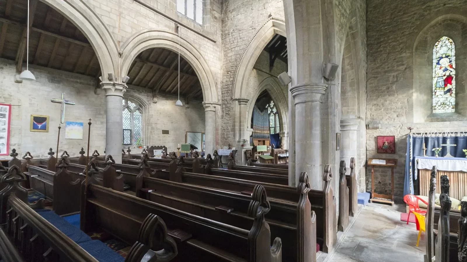 Empty wooden pews inside an old stone church