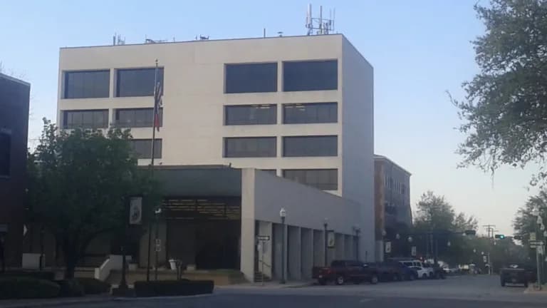 Conroe City Hall, a multistory white building on a downtown street