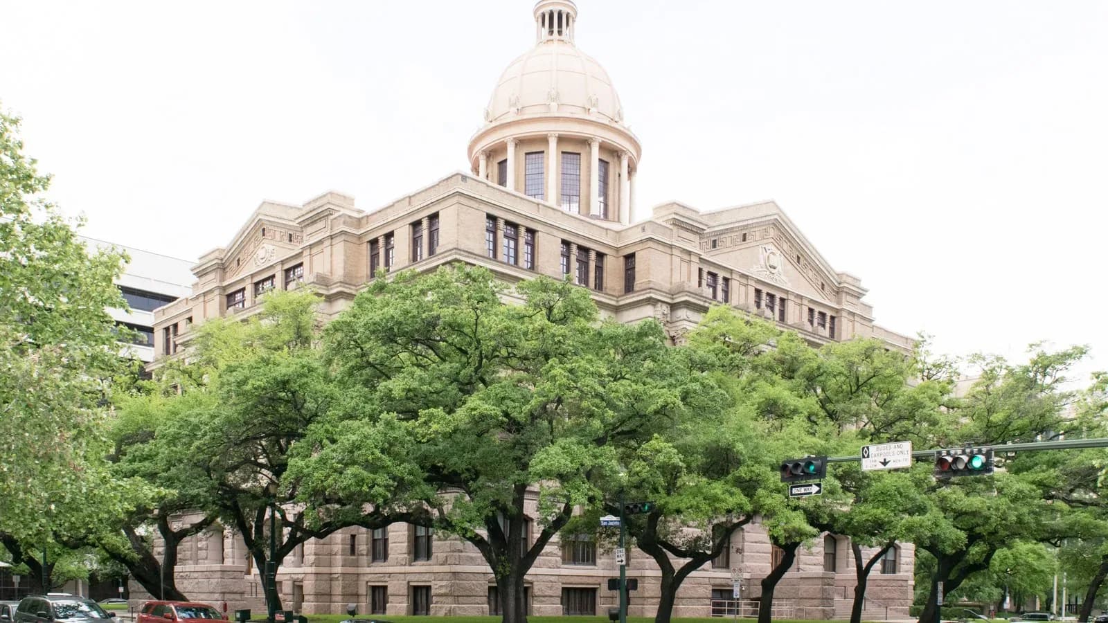 The restored 1910 Harris County Courthouse in downtown Houston, framed by live oaks
