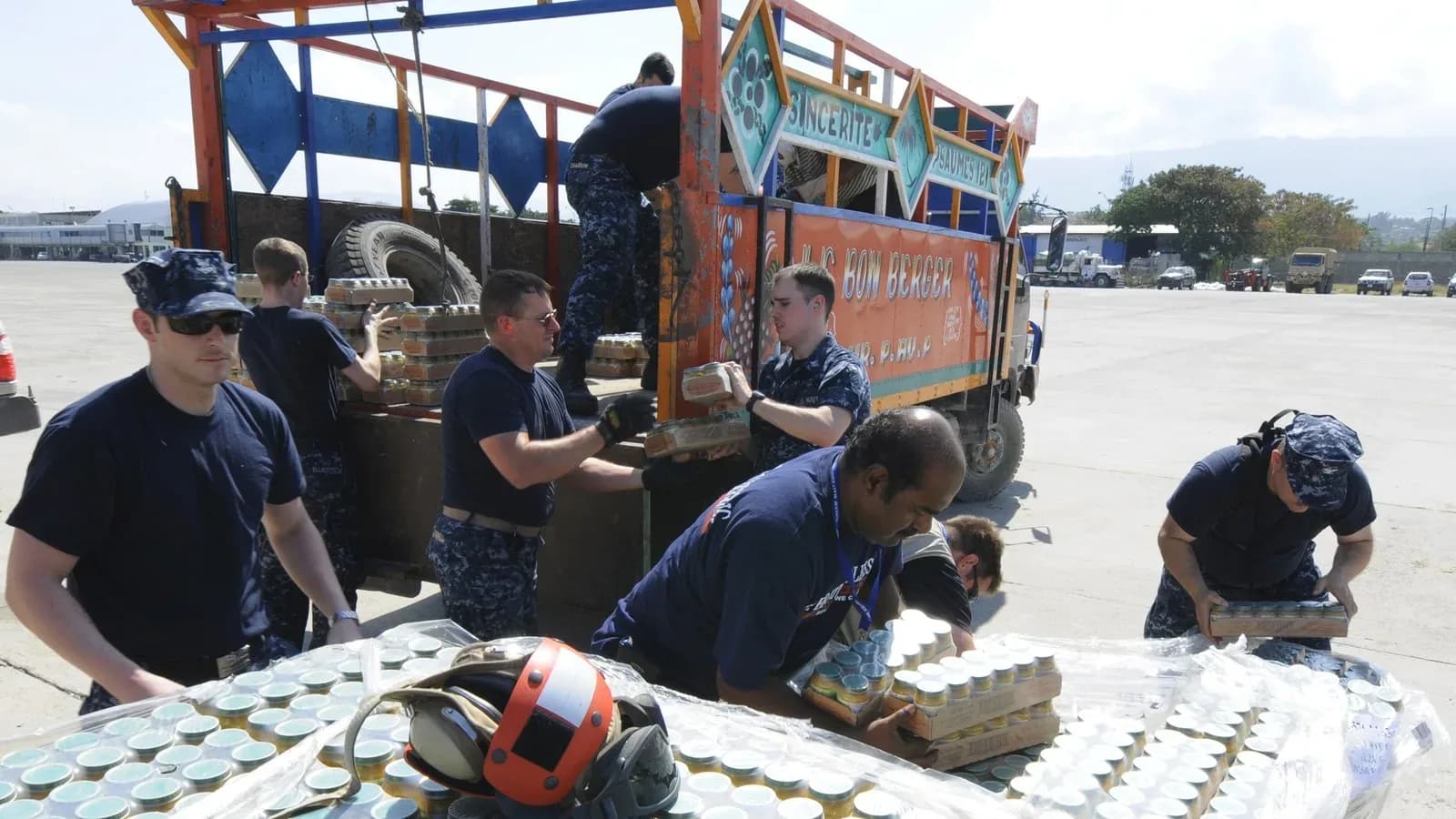Sailors loading jars of baby food onto a truck