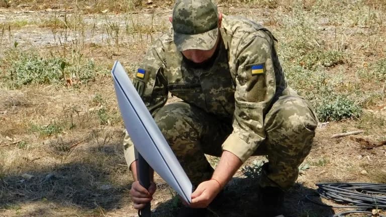 A Ukrainian soldier installing a Starlink satellite terminal