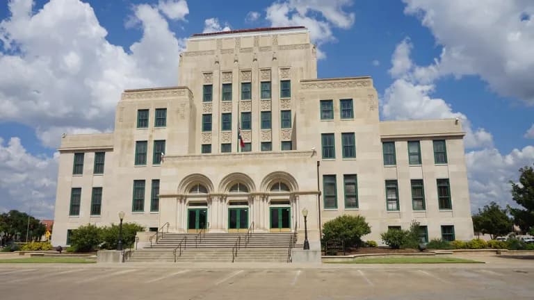 San Angelo City Hall, a pale stone Art Deco building, under a blue sky with clouds
