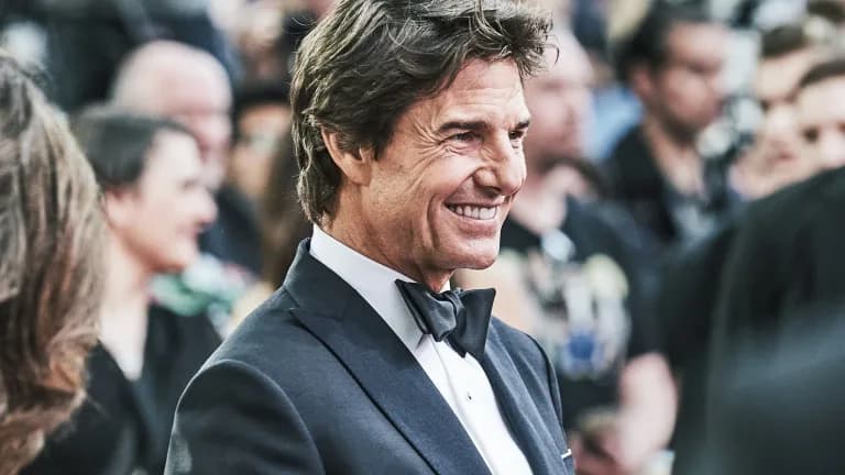 Tom Cruise smiling in a tuxedo at a movie premiere