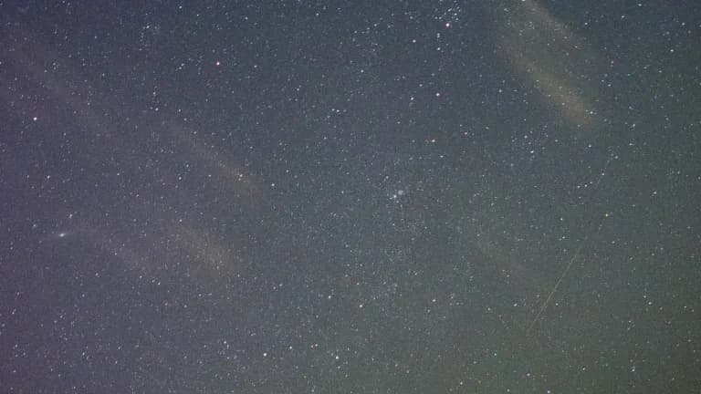 An Orionid meteor streaking across a starry night sky