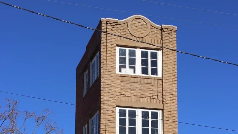 The narrow four-story brick Newby-McMahon Building in downtown Wichita Falls against a blue sky