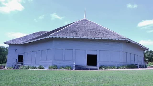 The many-sided Chautauqua auditorium with a shingled roof on the lawn of Getzendaner Park