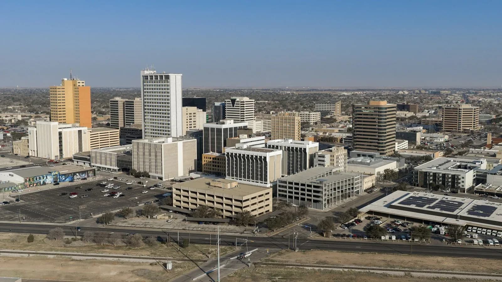 Downtown Midland office towers and parking lots seen from above under a hazy sky