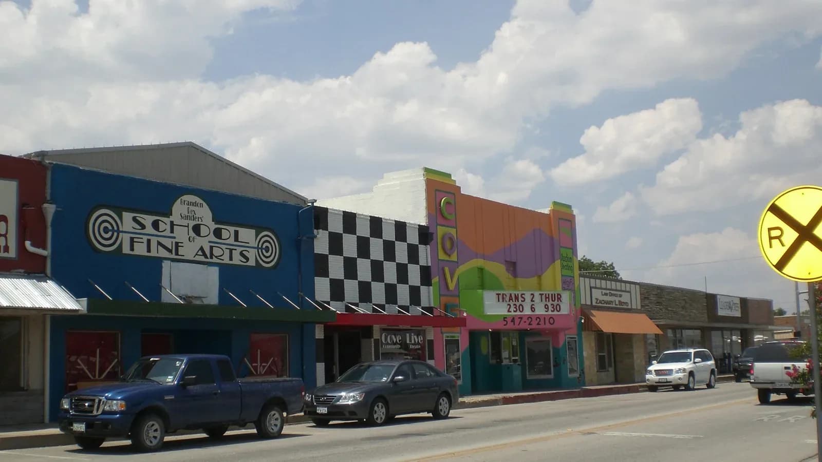 Colorful storefronts along Avenue D in downtown Copperas Cove with pickup trucks parked out front