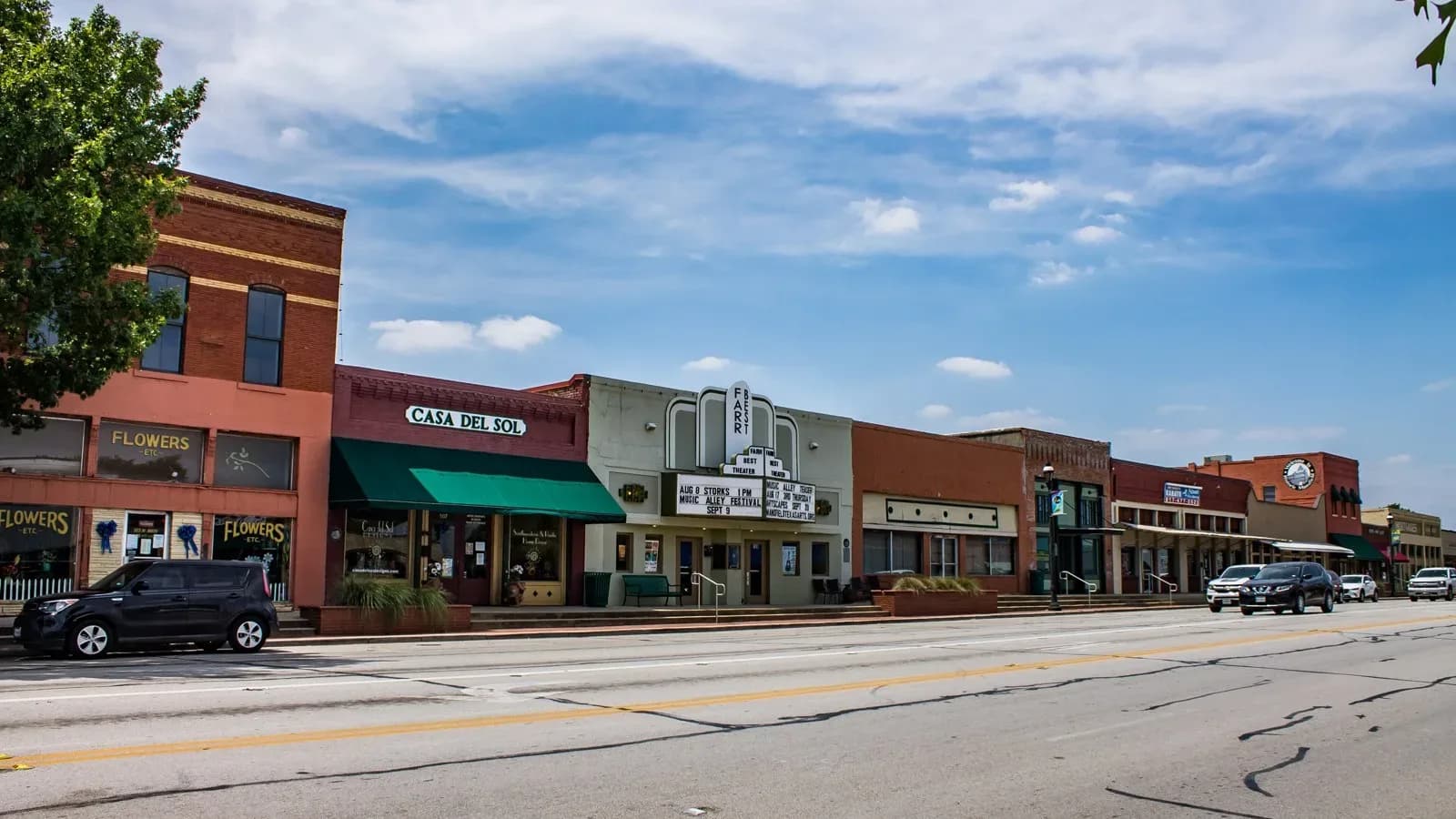 Brick storefronts along a street in downtown Mansfield, Texas under a blue sky