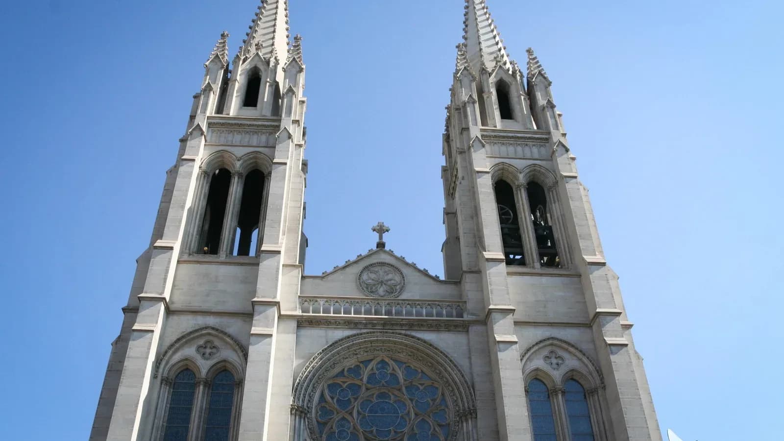 The twin Gothic spires of the Cathedral Basilica of the Immaculate Conception in Denver against a blue sky
