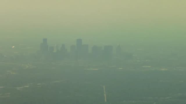 Downtown Houston skyscrapers seen through a brown haze of smog