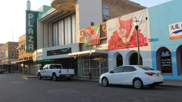 The former Plaza Theatre and storefronts along a street in downtown Laredo