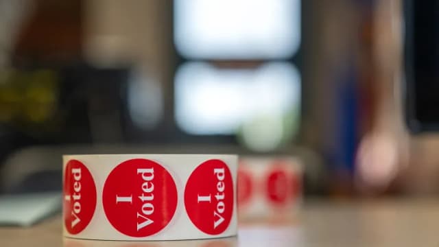 A roll of red, white and blue I Voted stickers on a table
