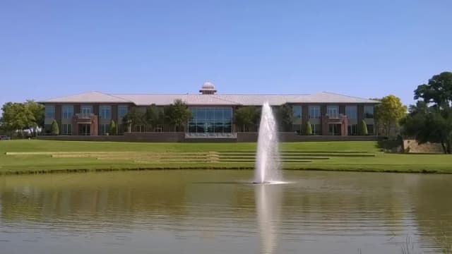 Keller City Hall across a pond with a fountain on a clear day