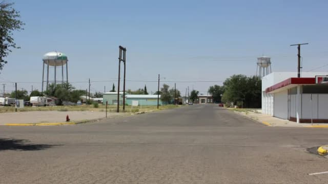 A wide street in Kermit, Texas, with two water towers on the skyline