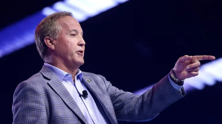 Texas Attorney General Ken Paxton gestures while speaking on stage