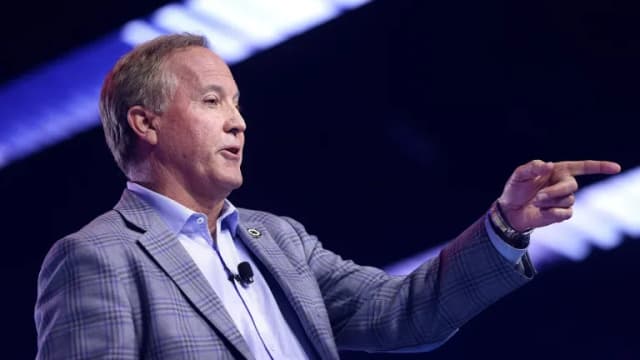 Texas Attorney General Ken Paxton gestures while speaking on stage