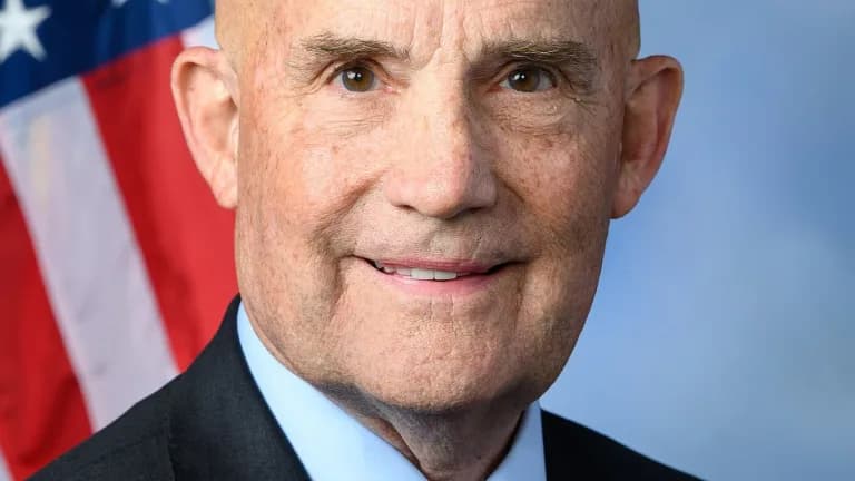 Official portrait of U.S. Rep. Keith Self in a dark suit and tie in front of an American flag