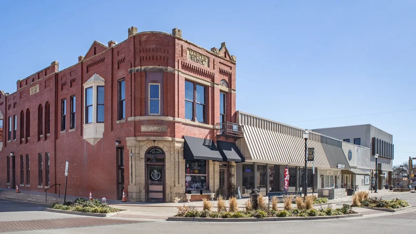A red brick corner building on a downtown street in Kaufman, Texas