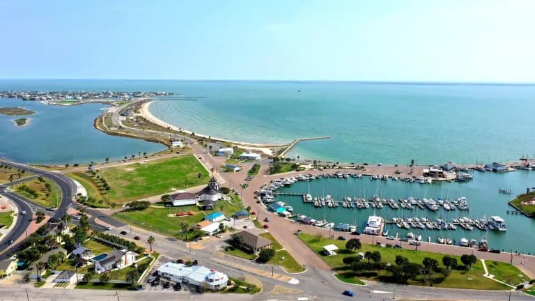 Aerial view of the Rockport, Texas, waterfront with a marina and beach on Aransas Bay