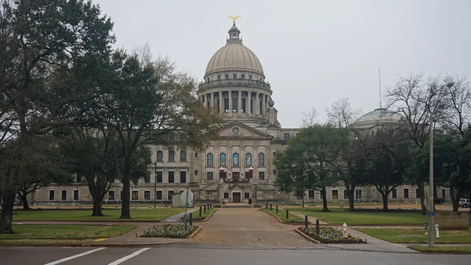 The Mississippi State Capitol in Jackson, with its domed building at the end of a walkway lined with trees