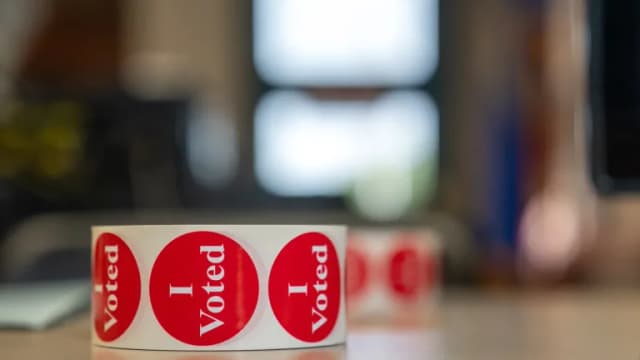 A roll of red I Voted stickers on a table at a polling place