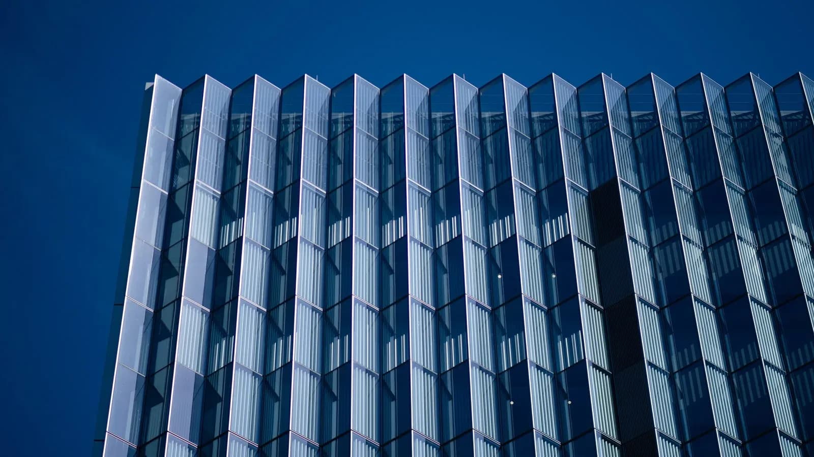 Glass facade of the First Street U.S. Courthouse against a blue sky in downtown Los Angeles