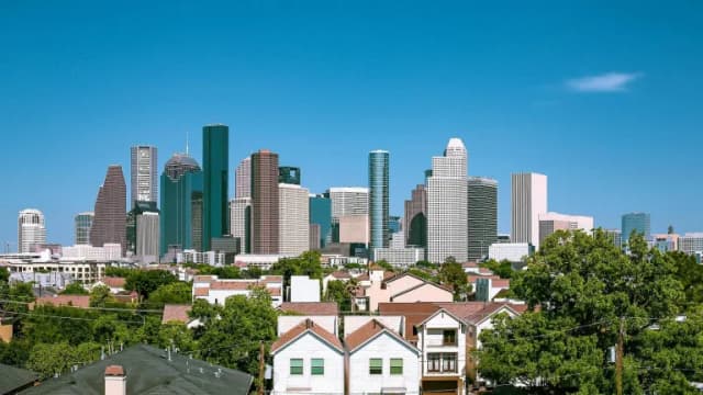 The downtown Houston skyline seen over the rooftops of nearby homes