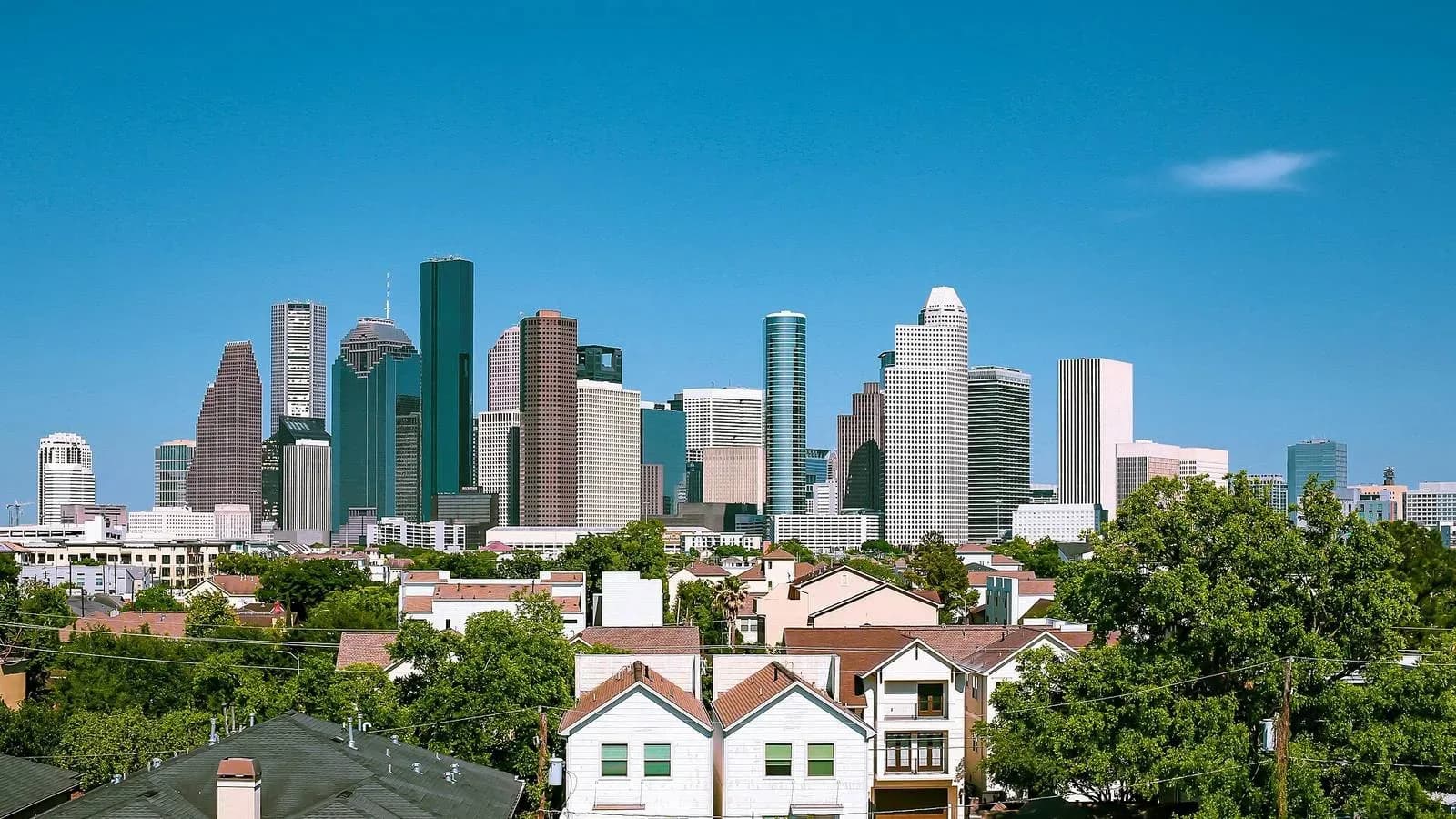 The downtown Houston skyline seen over the rooftops of nearby homes