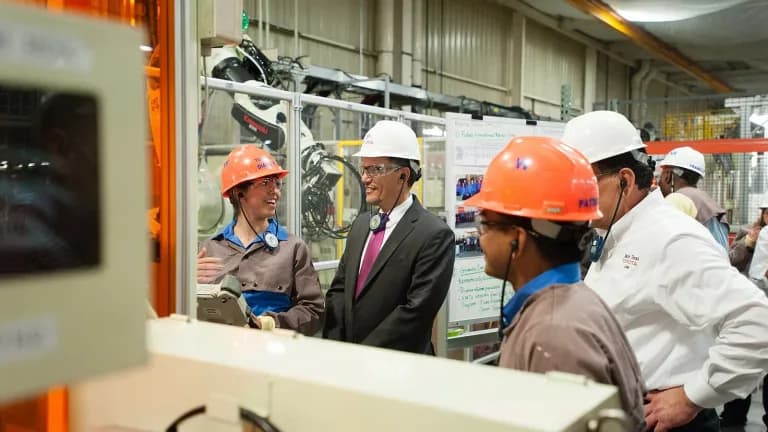 Workers in hard hats talk on the production floor of the Toyota plant in San Antonio