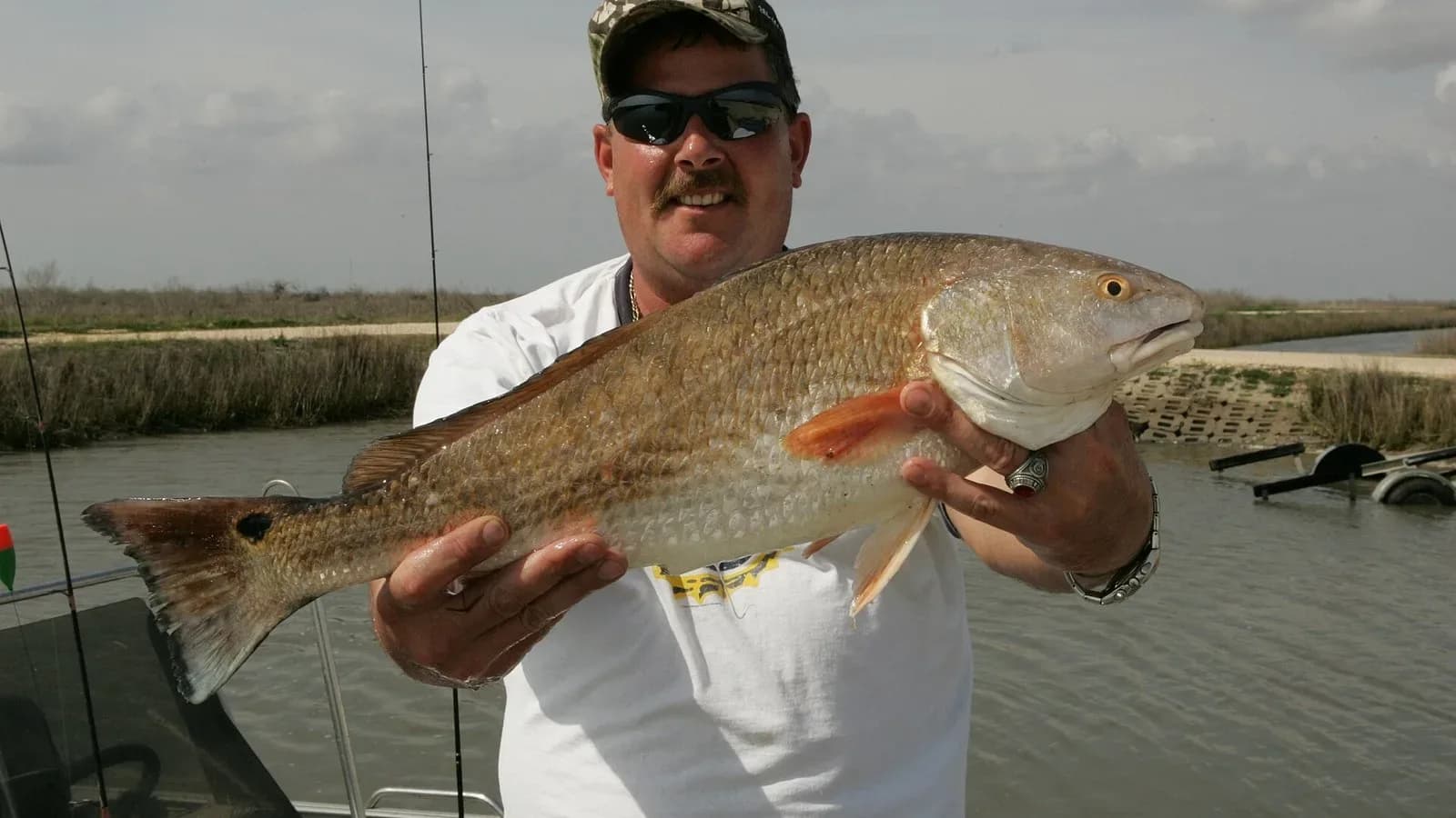 An angler holds up a red drum caught at Anahuac National Wildlife Refuge