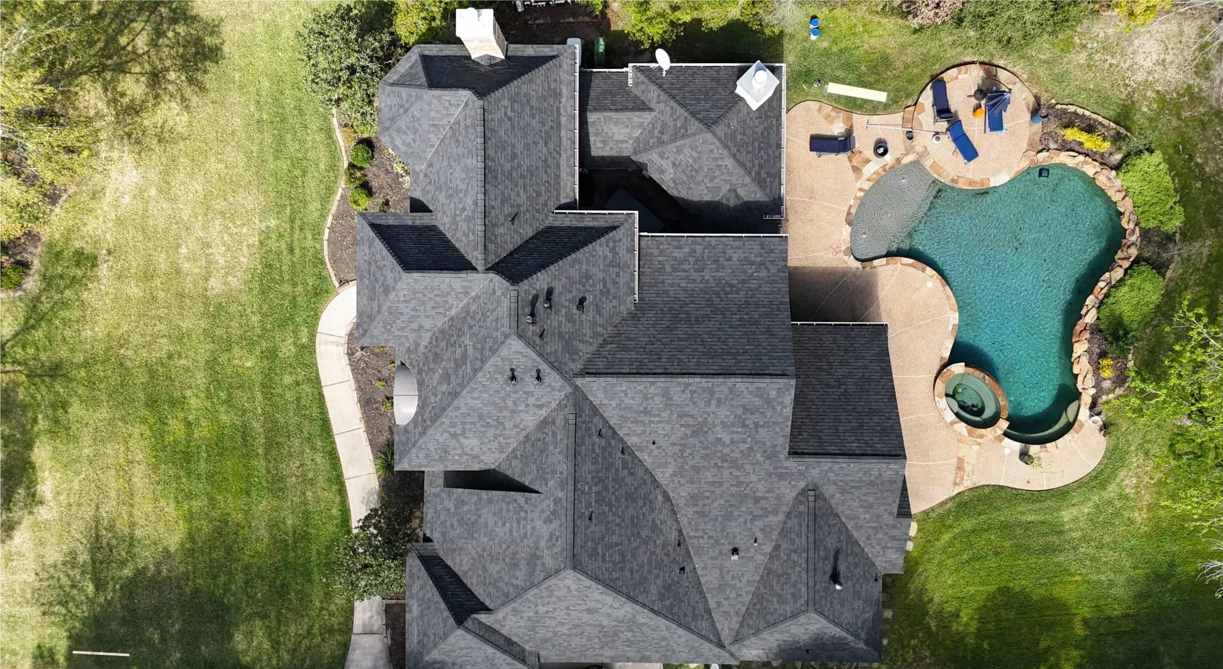 Aerial view of a finished architectural-shingle roof on a large house