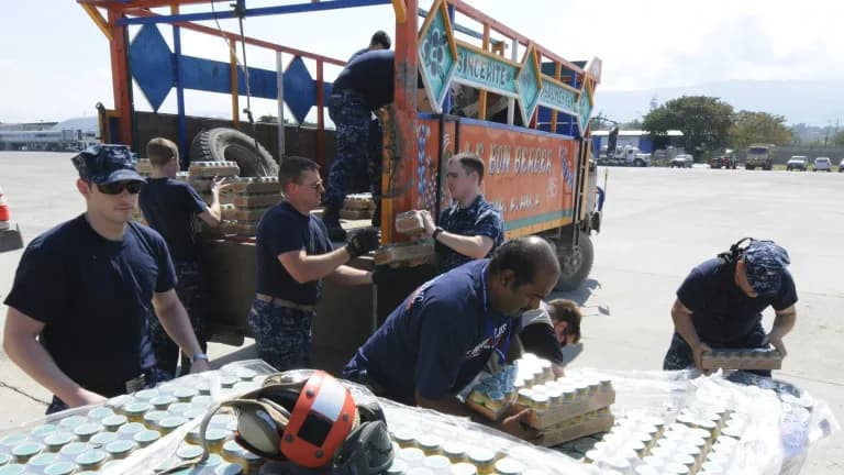 Sailors loading jars of baby food onto a truck
