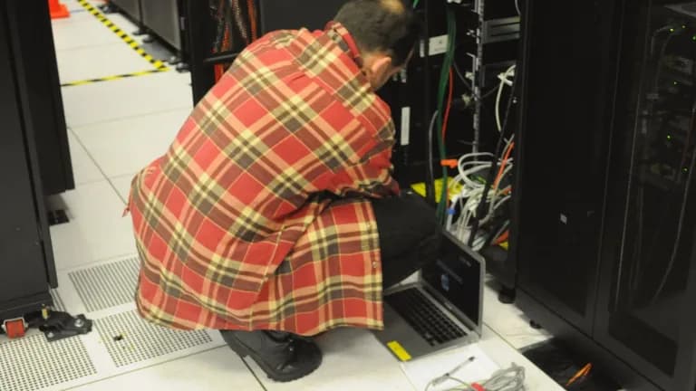 A technician working on a server rack in a data center