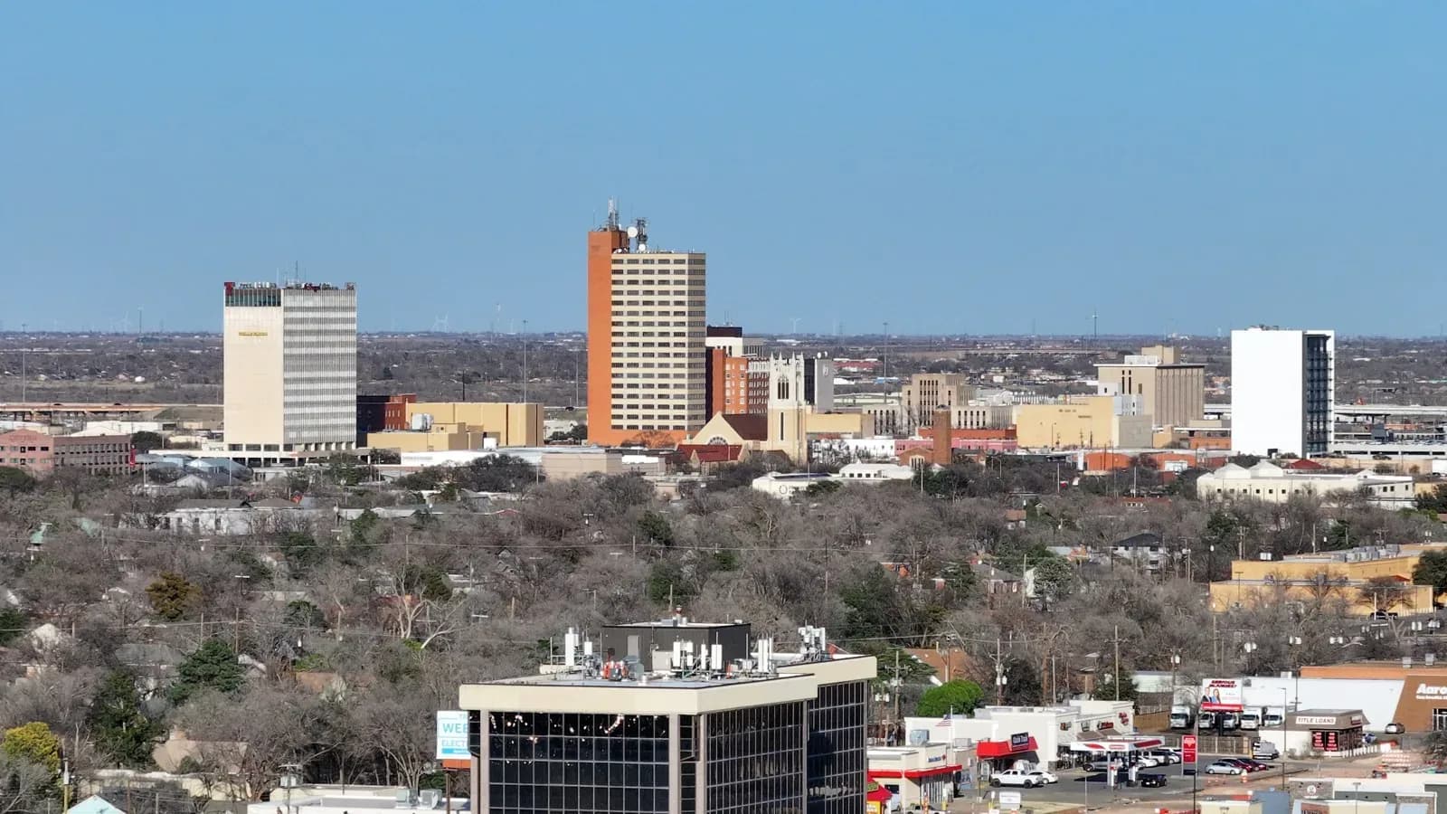 The Lubbock skyline with office towers rising above tree-lined neighborhoods