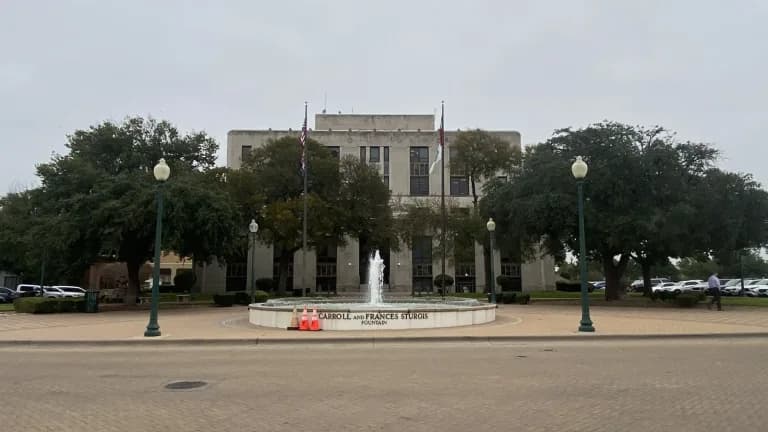 Waco City Hall, a pale stone building behind a fountain and flagpoles