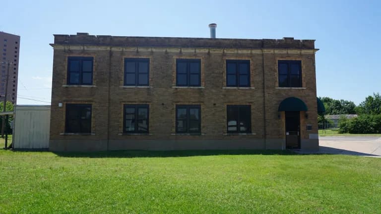 Abilene's former Fire Station No. 2, a two-story tan brick building on a green lawn
