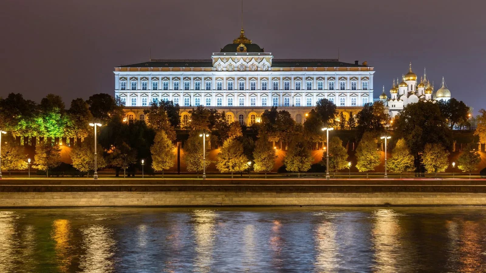 The Grand Kremlin Palace lit up at night above the Moskva River in Moscow