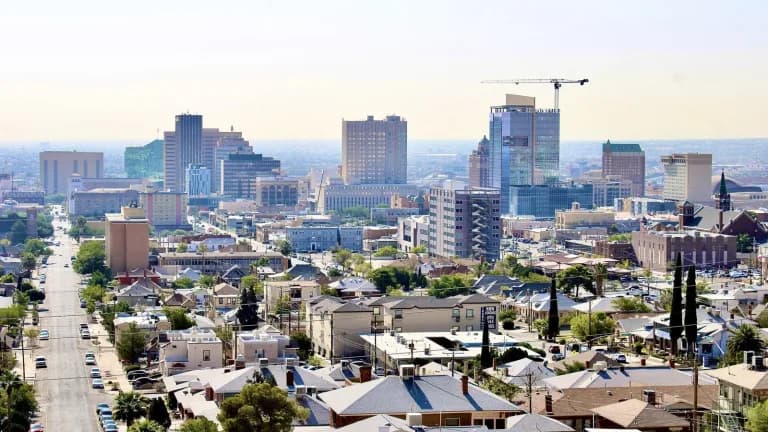 Downtown El Paso skyline rising above neighborhoods of low houses and tree-lined streets