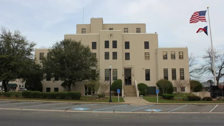 Titus County Courthouse in Mount Pleasant, Texas, a tan stone building with a clock