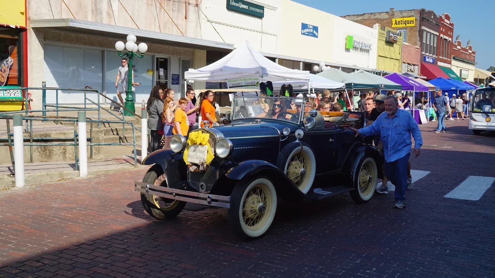 A dark Ford Model A driving in a small-town Texas parade