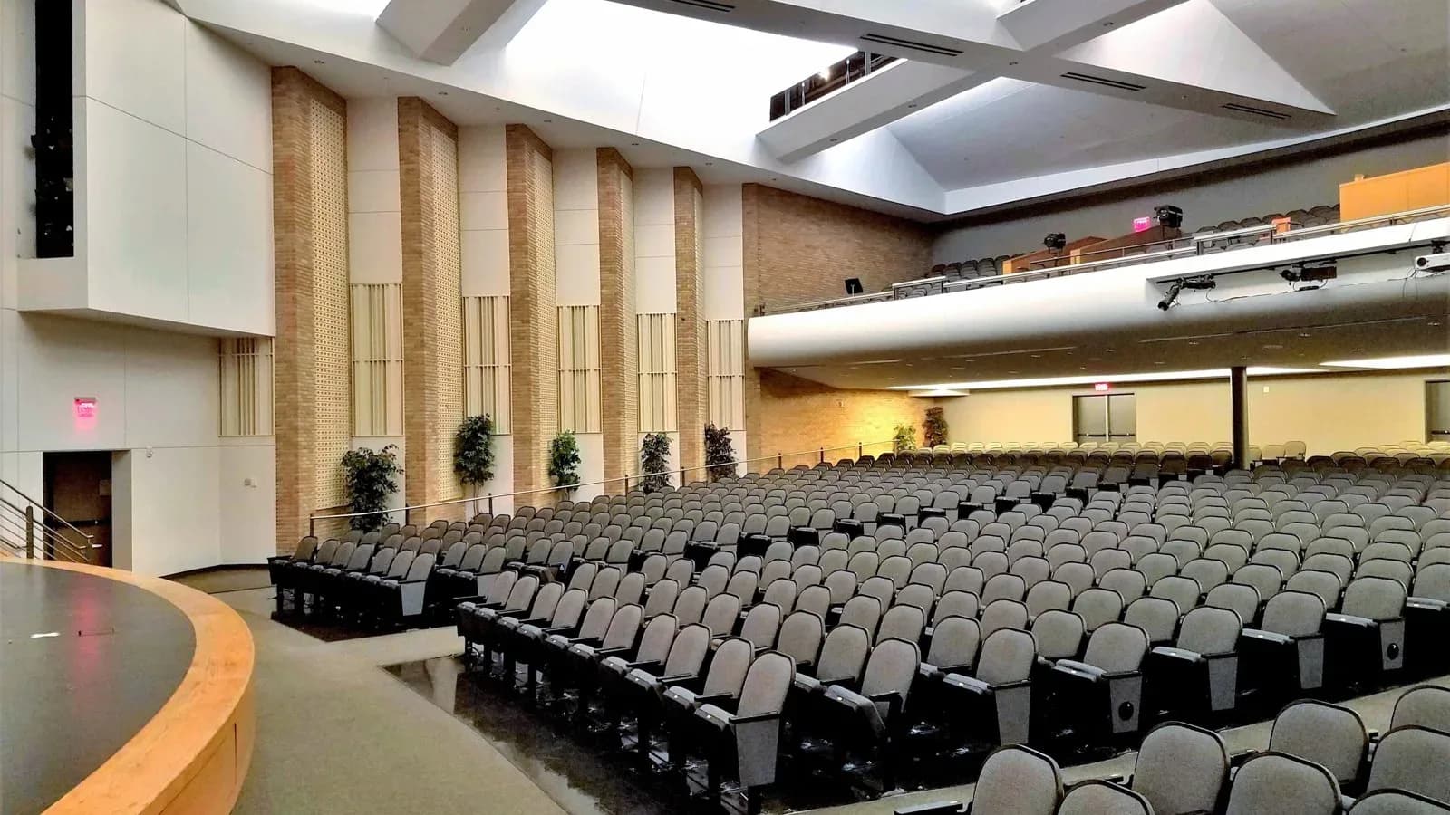 Rows of gray seats in the Irving High School auditorium beneath a high ceiling