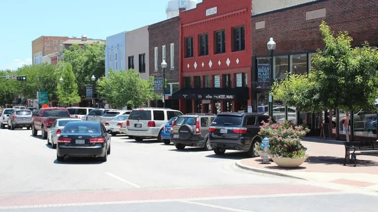 Cars parked along brick storefronts on the historic downtown square in McKinney