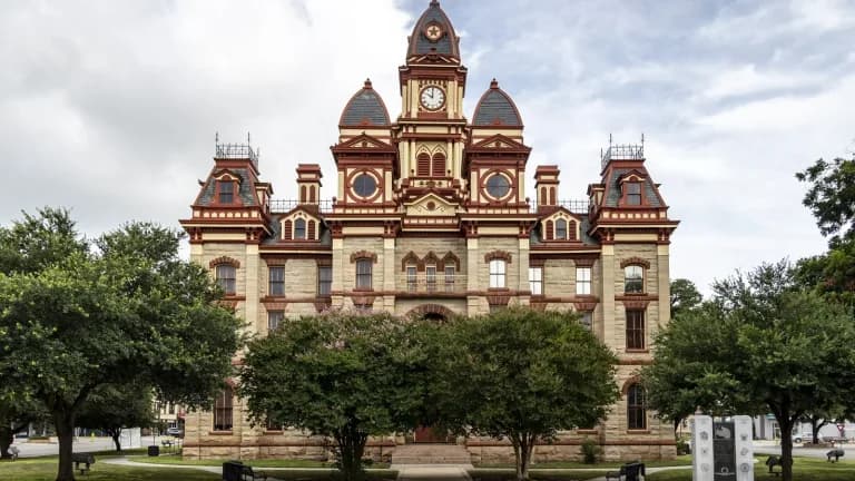 The ornate stone and red-trimmed Caldwell County Courthouse in Lockhart with a central clock tower
