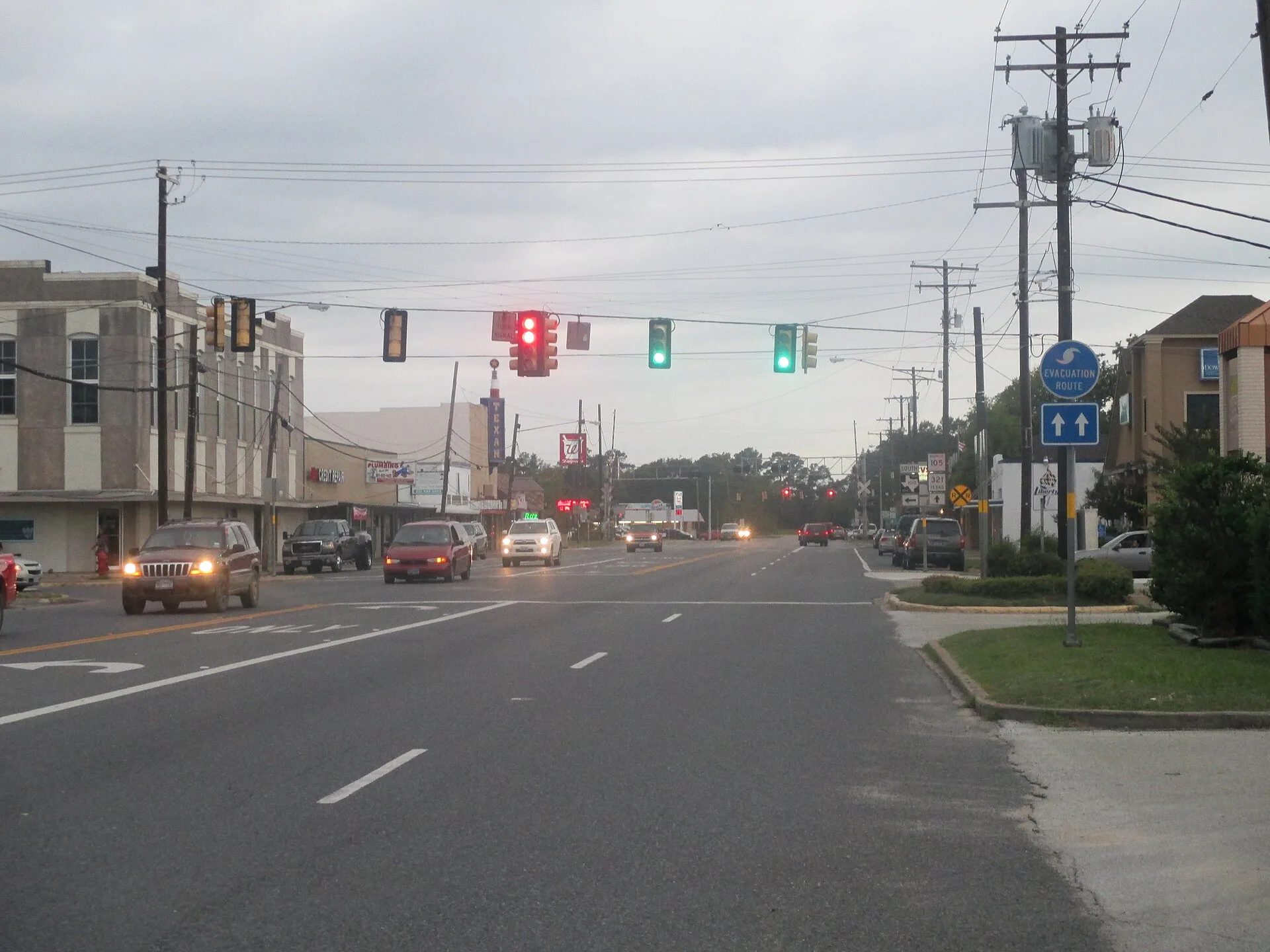 Downtown Cleveland, Texas, looking along a wide commercial highway with storefronts and a railroad crossing sign