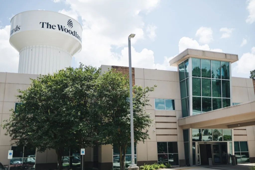The entrance of ClearChoice Dental Implant Center in The Woodlands, with The Woodlands water tower beside the building.
