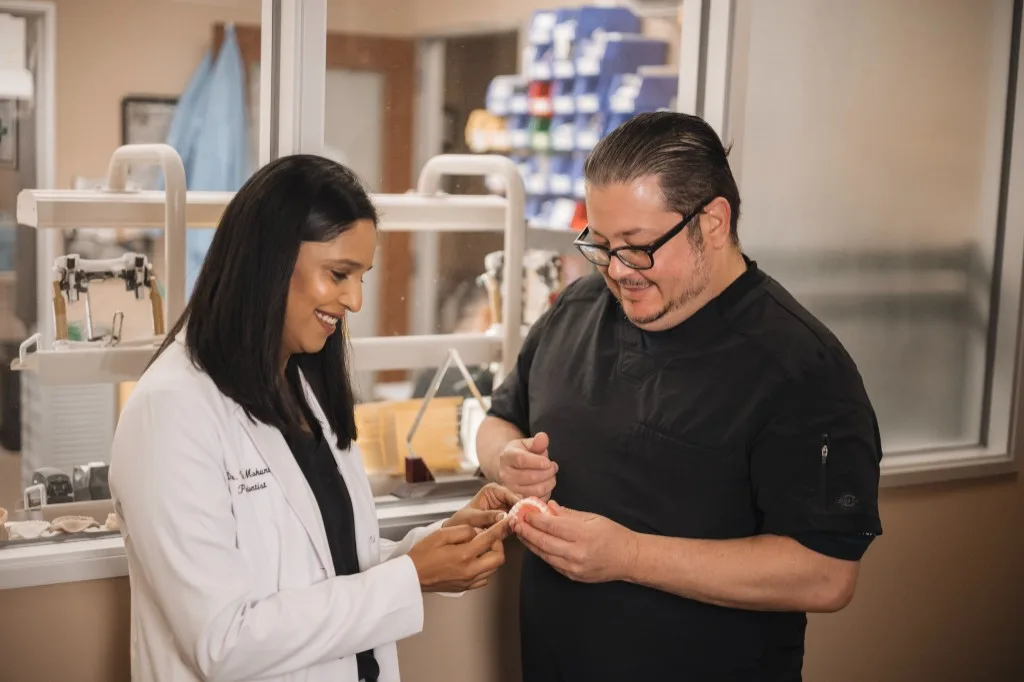 Dr. Vrinda Mohunta reviews a dental restoration model with a colleague at ClearChoice in The Woodlands.